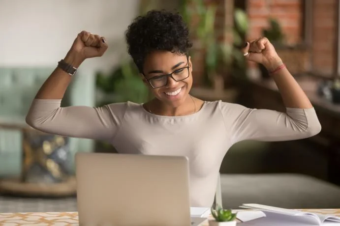 triumphant lady showing victorious joy over laptop computer