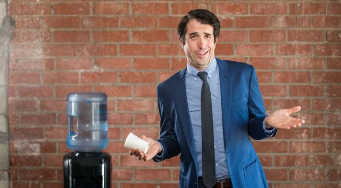 man shrugging by water cooler - has an idunno face