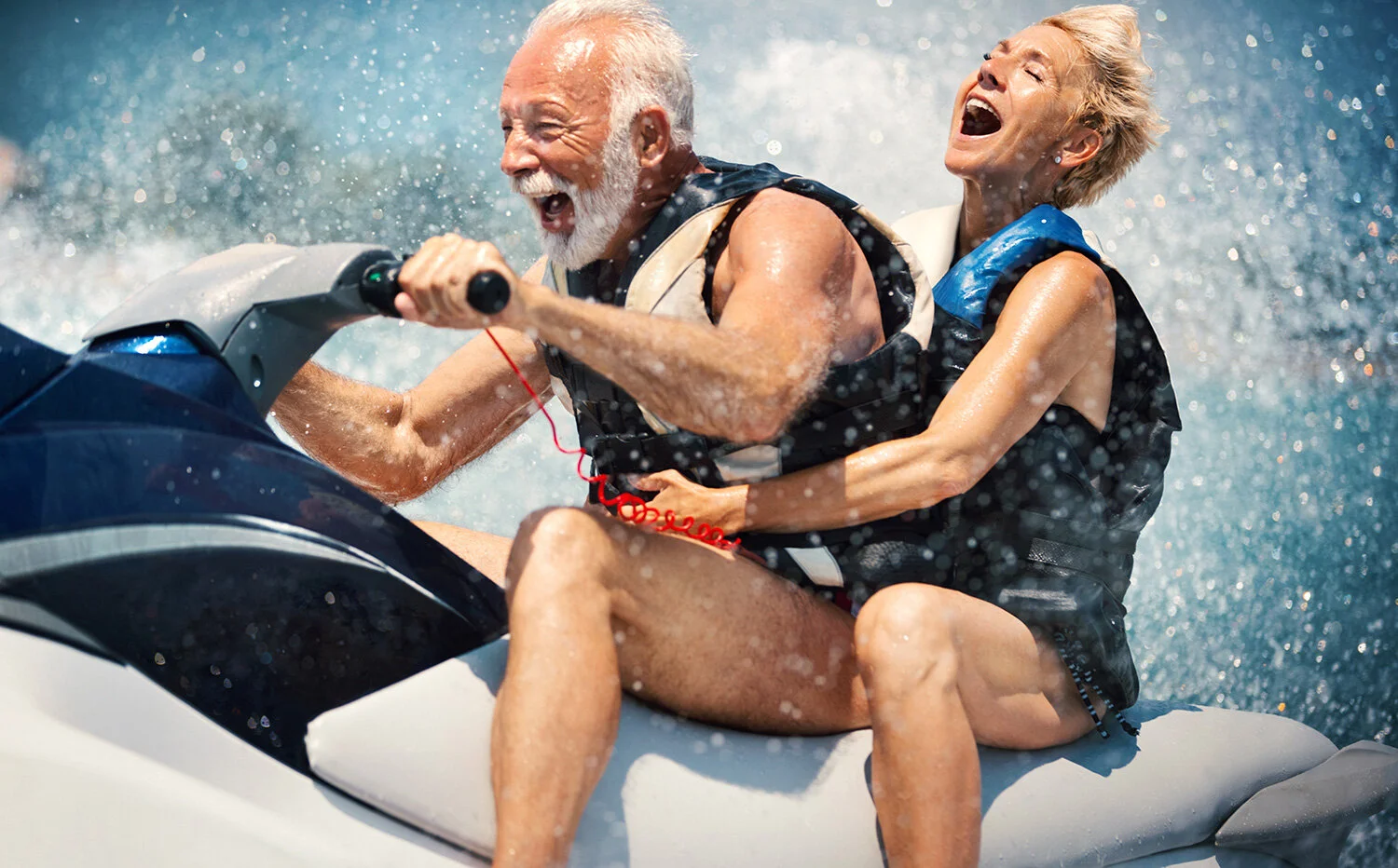 older couple on jet skis laughing