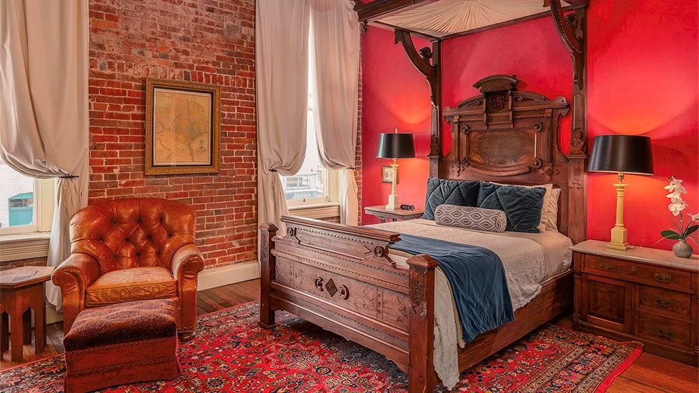 A gorgeous bedroom with a brick wall and red floor rug