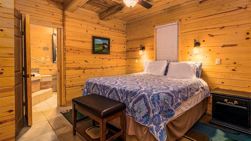 Log cabin style bedroom with a comfortable bed