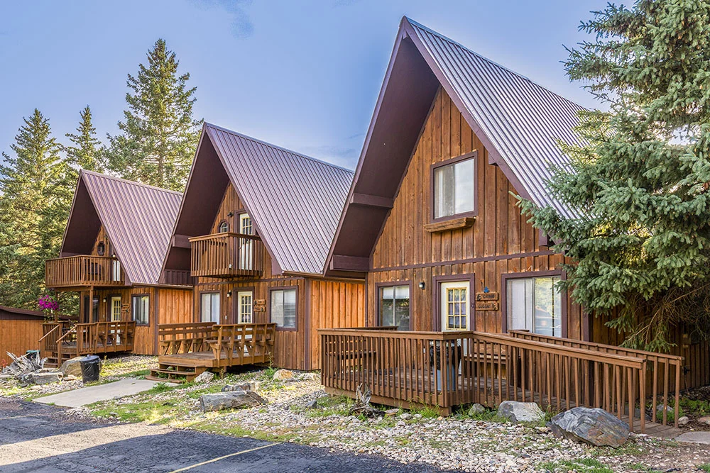 three log cabins under a blue sky