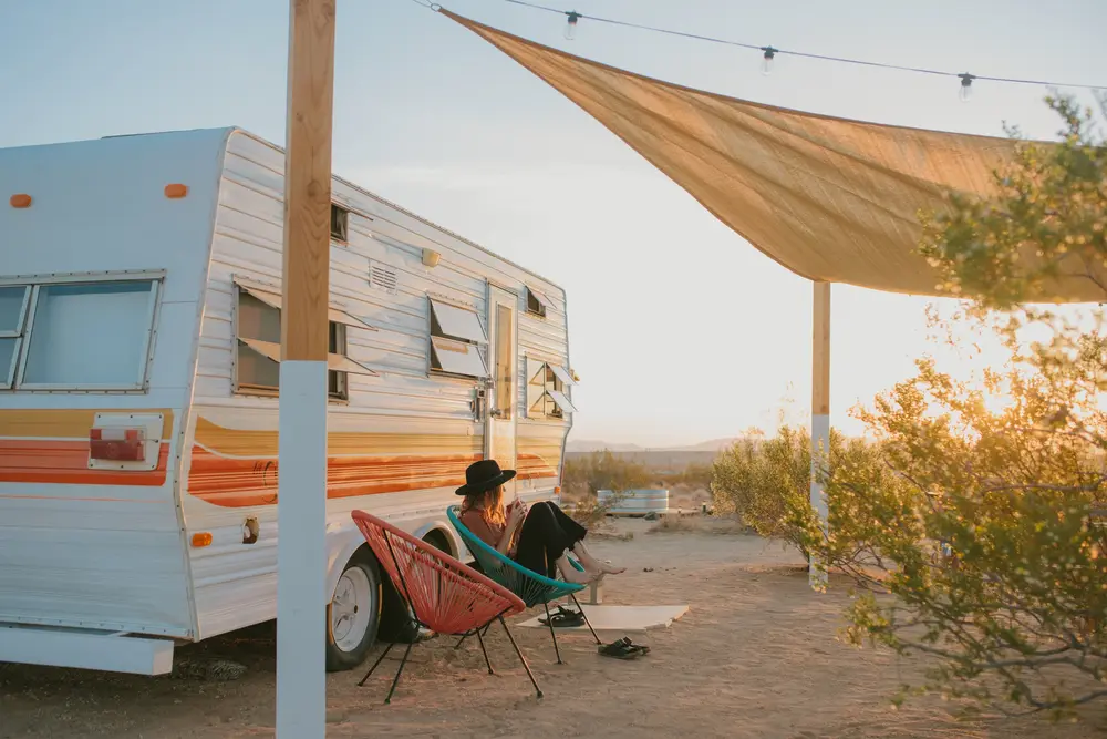 Old RV with woman in cowboy hat
