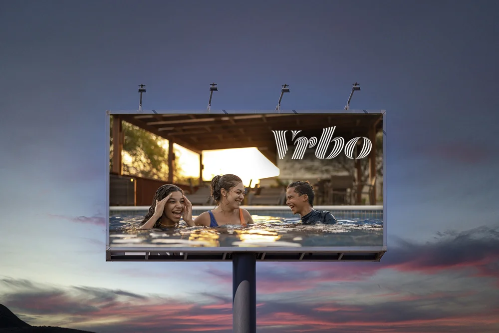 billboard of latin family swimming in pool with Vrbo logo
