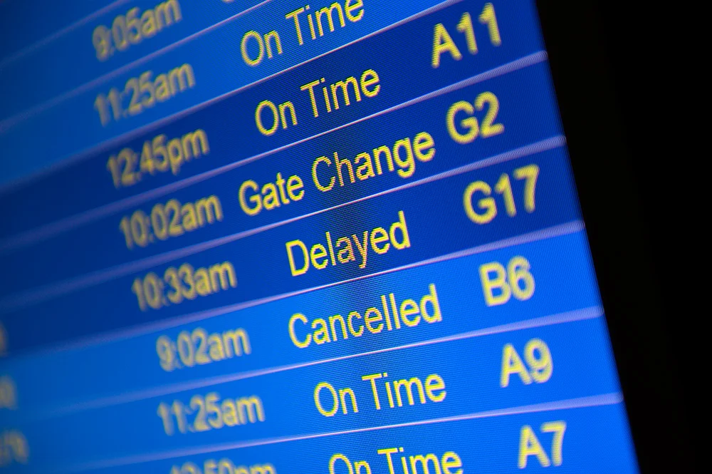 Airport sign showing cancelled and delayed flights