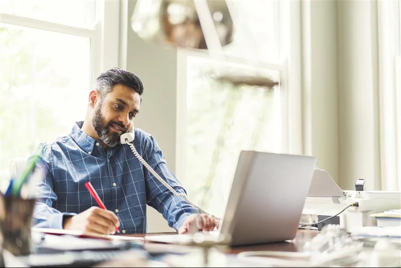 man on the phone at his computer