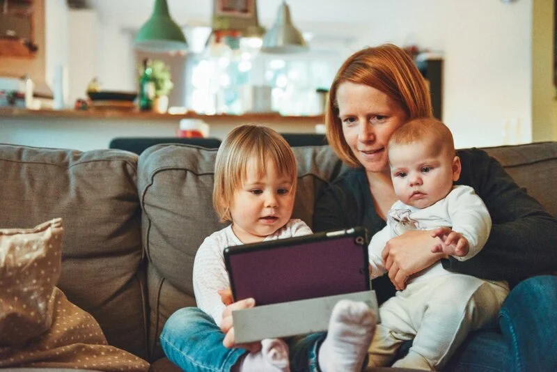 mom with two kids looking at tablet